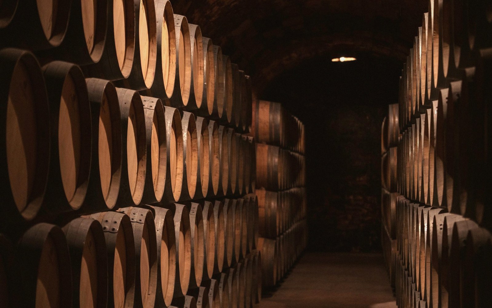 Barrels ranked in a gallery, receding into the dark