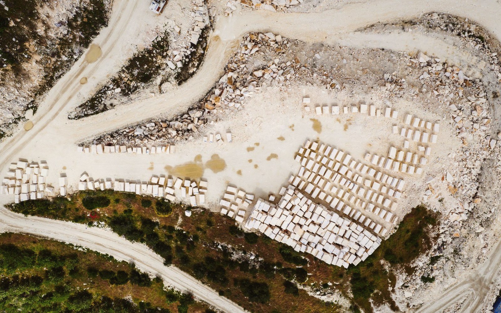 Aerial view of cut stone blocks stacked in rows at a quarry site